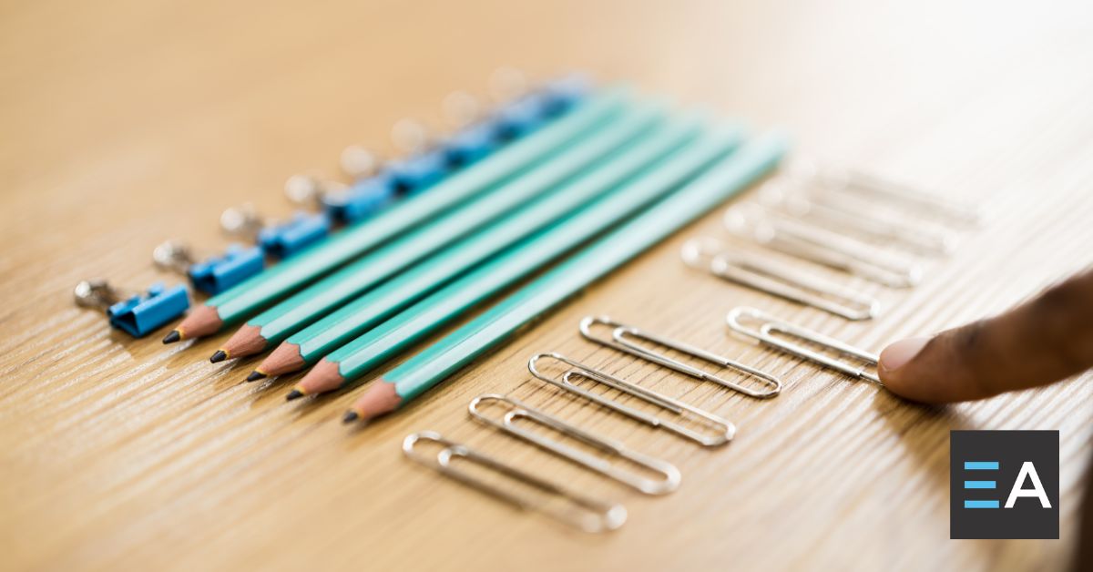 A person lining up office supplies