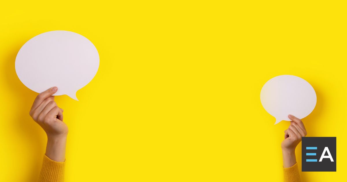 Hands holding up white speech bubbles in front of a yellow background