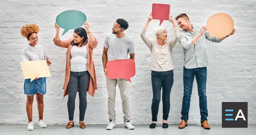 Five people holding cutouts of speech bubbles standing side by side