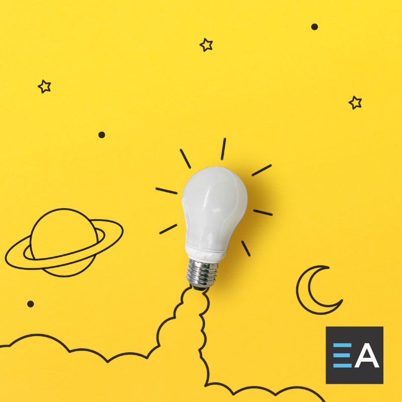 A lightbulb with drawings of rocket and space imagery drawn around it on a yellow background