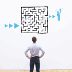 A person faces a wall with a drawing of a maze on it.