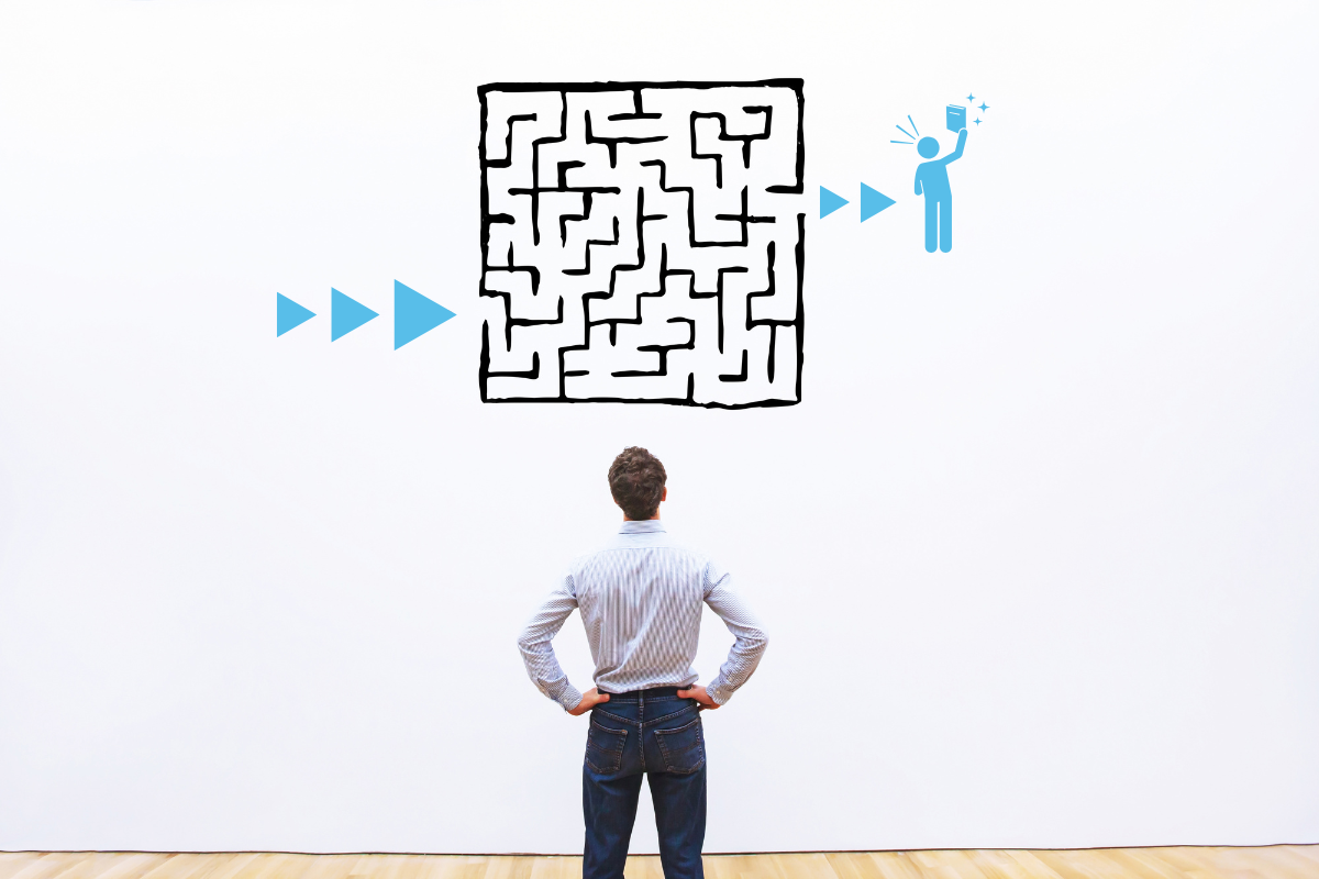 A person faces a wall with a drawing of a maze on it.