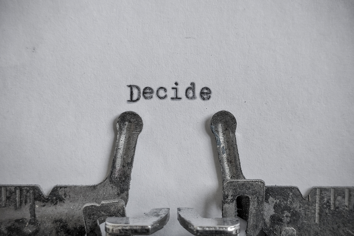 A typewriter writes the word decide