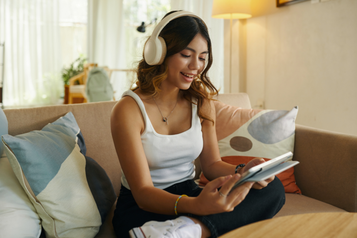 Author reviewing a finished book beside headphones while considering an audiobook edition