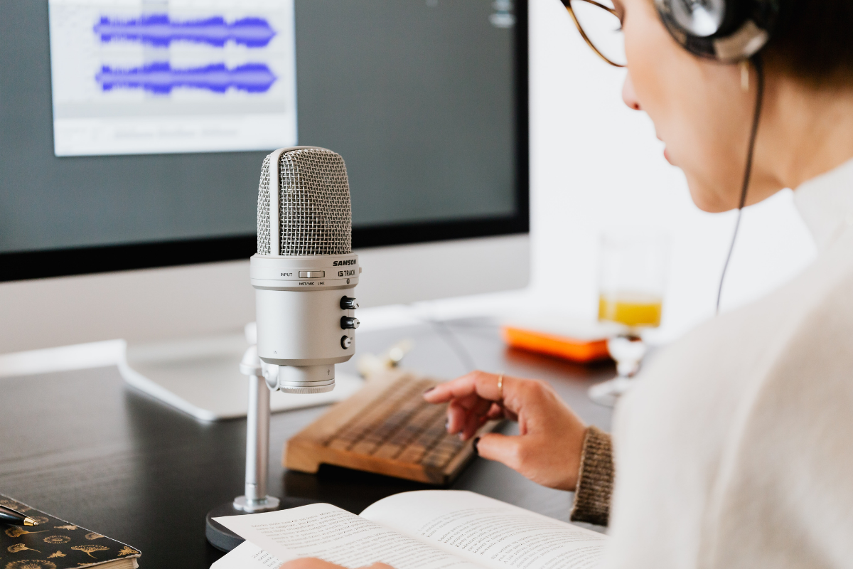 Narrator recording a manuscript at a microphone during audiobook production