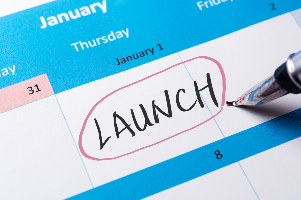 A person circles the word launch on a calendar