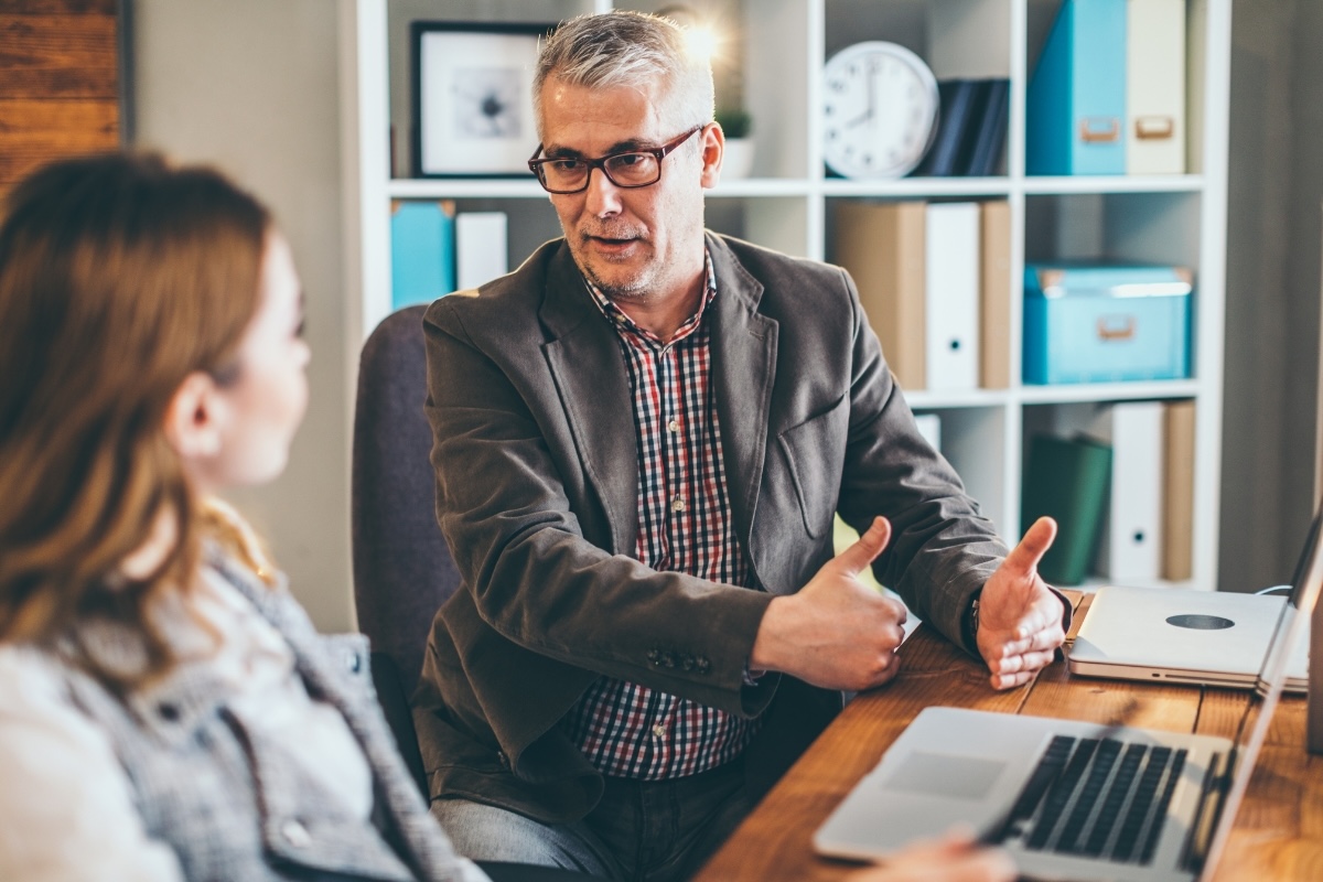 A book coach guides an author at a laptop
