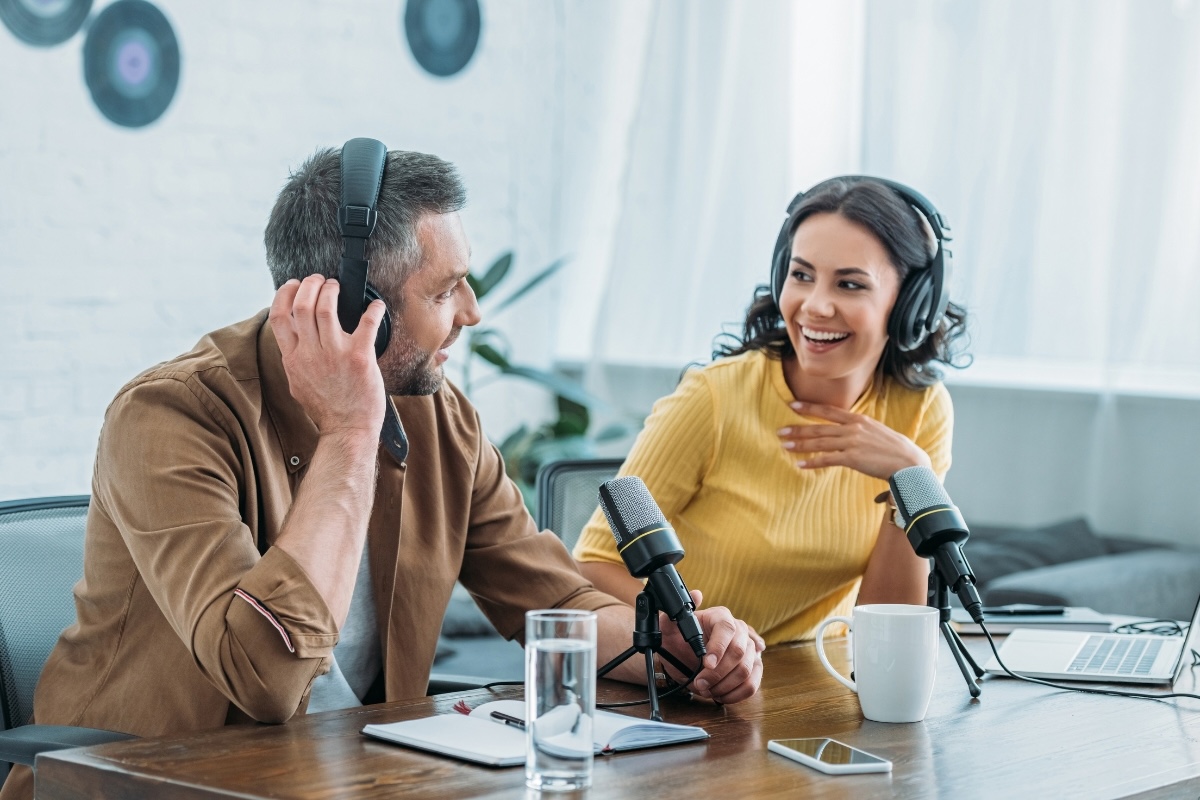 Two people wearing headphones exchange business book ideas