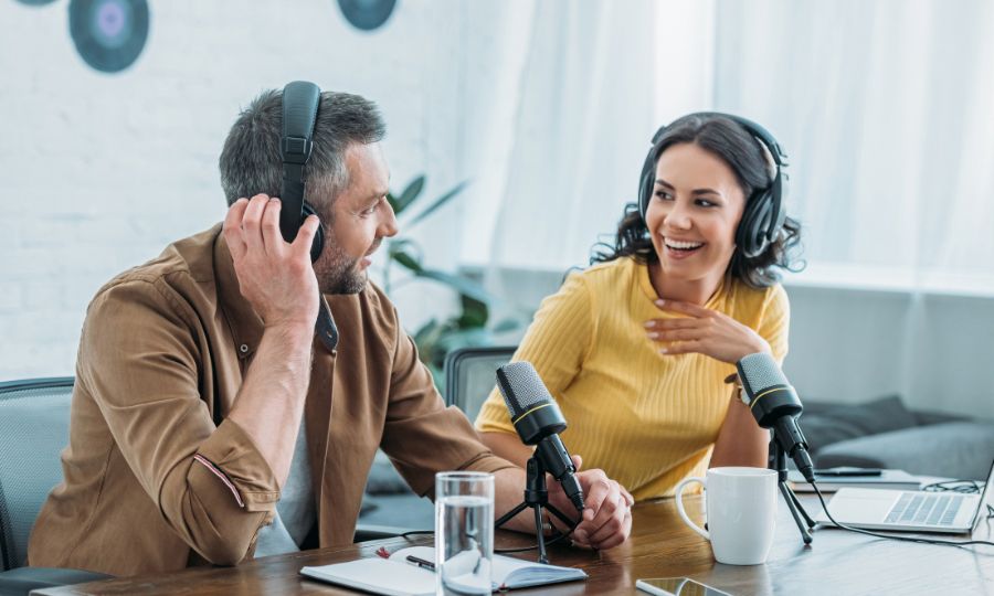 Two people wearing headphones exchange business book ideas