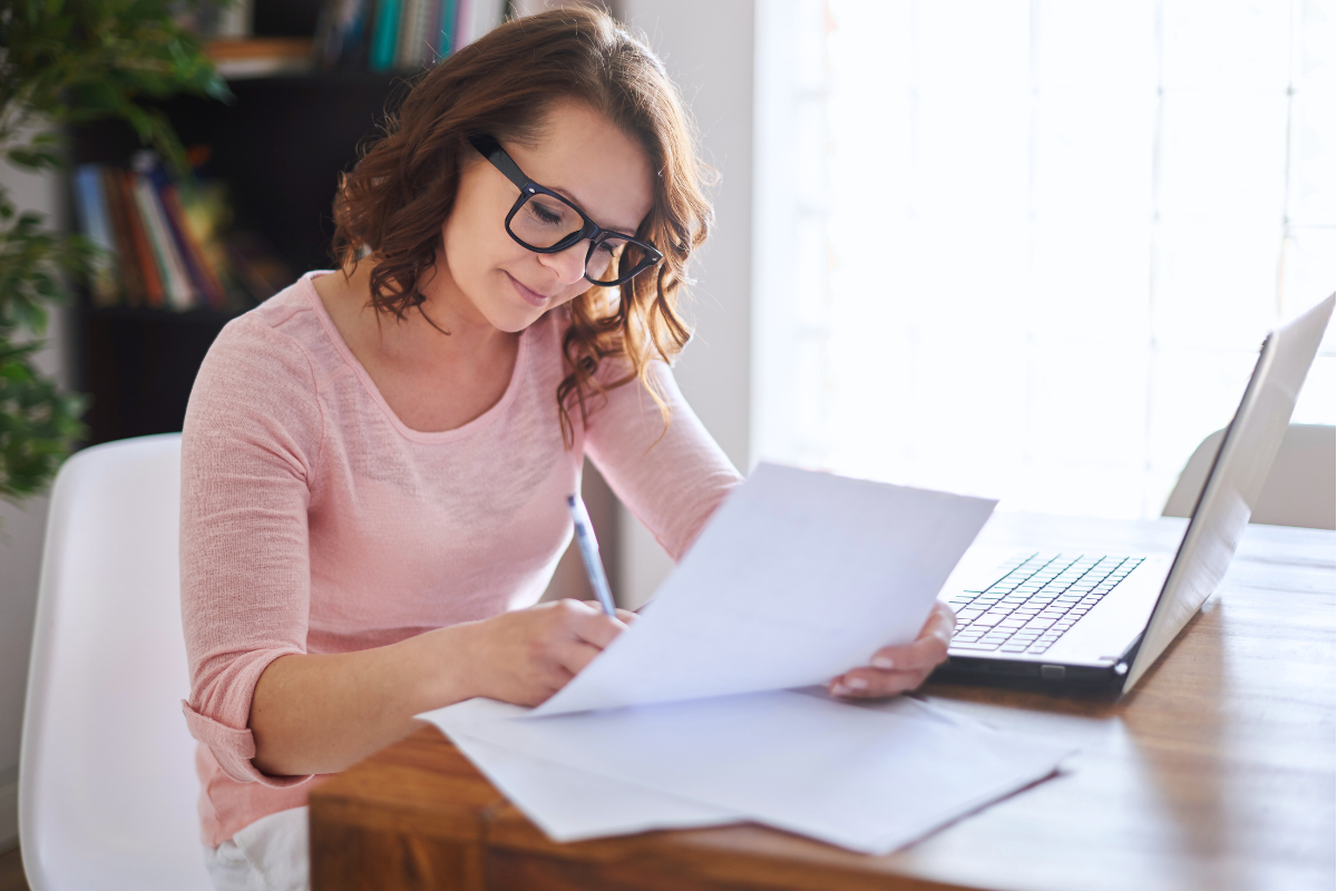A business writer overcomes writer's block by taking notes on sheets of paper