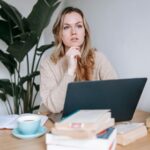 An author seated at a work table considers business book revision