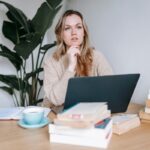 An author seated at a work table considers business book revision