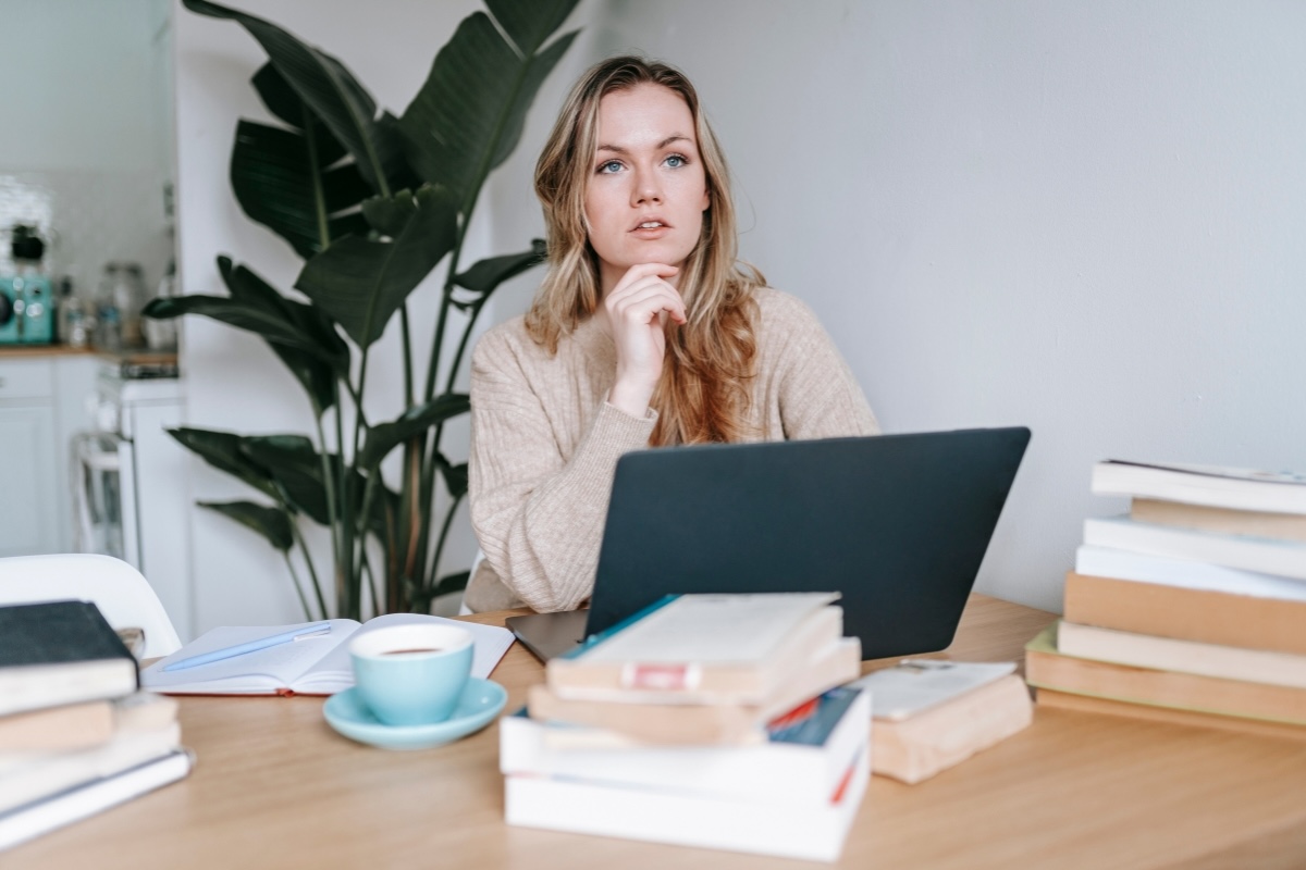 An author seated at a work table considers business book revision