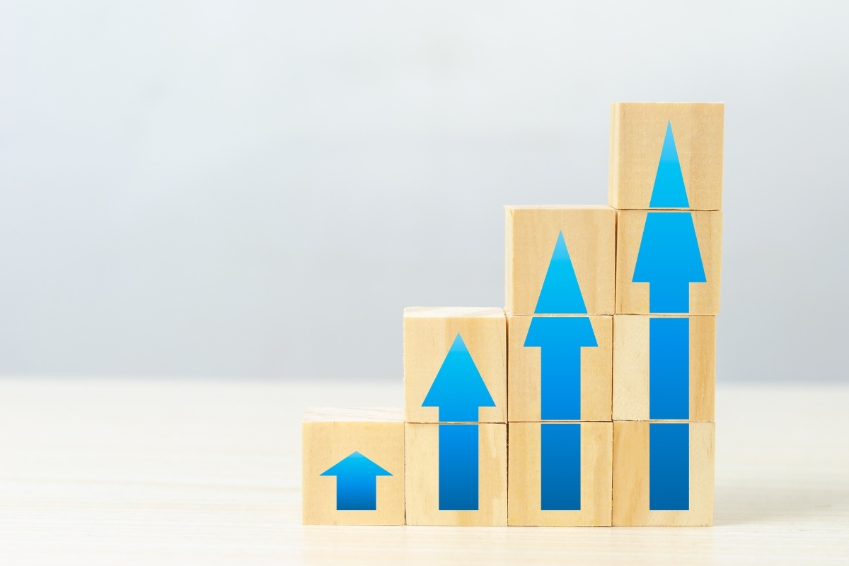 Four wooden blocks with arrows on them arranged from shortest to tallest
