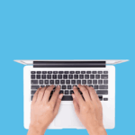 A person types a well-written book description on a laptop