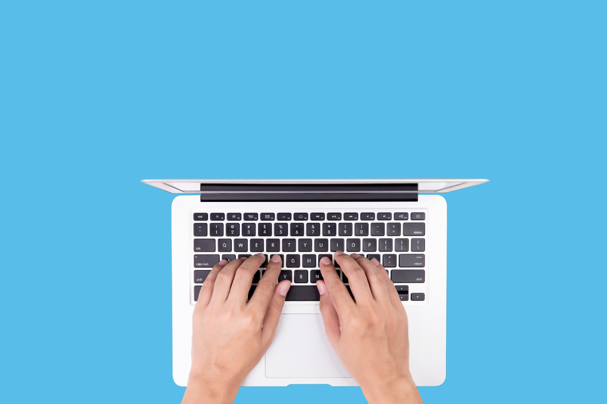 A person types a well-written book description on a laptop