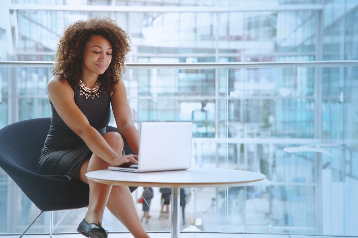 A person in a business environment types on a laptop.