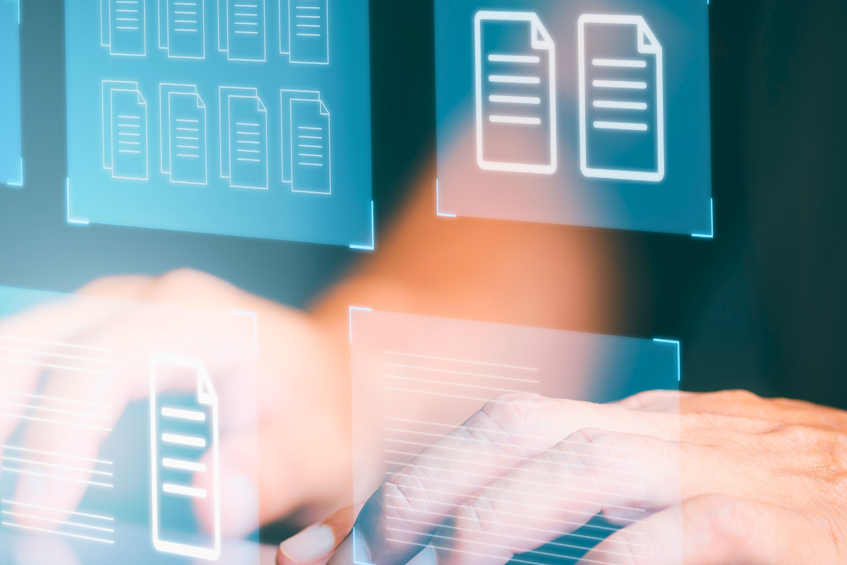 Typing hands behind images of document icons