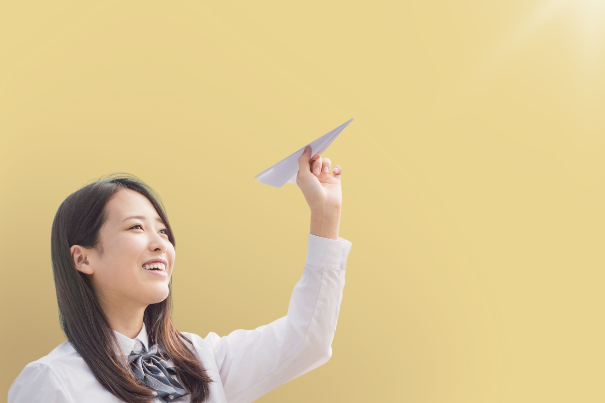 A person prepares to throw a paper airplane. 