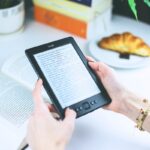A person at a cafe enjoys an ebook