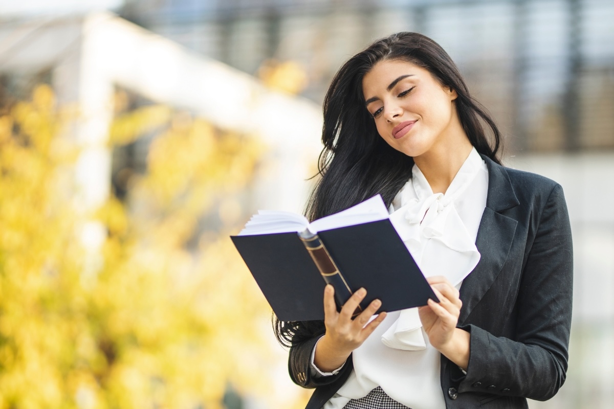 A business person smiles at a print book