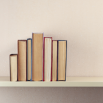A stack of books on a shelf, positioned with their pages out