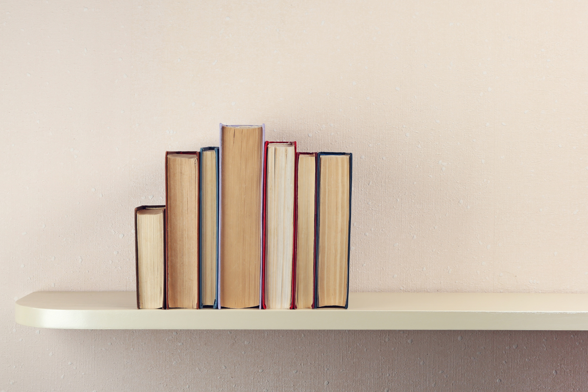 A stack of books on a shelf, positioned with their pages out
