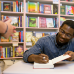 An author signs a copy of their book