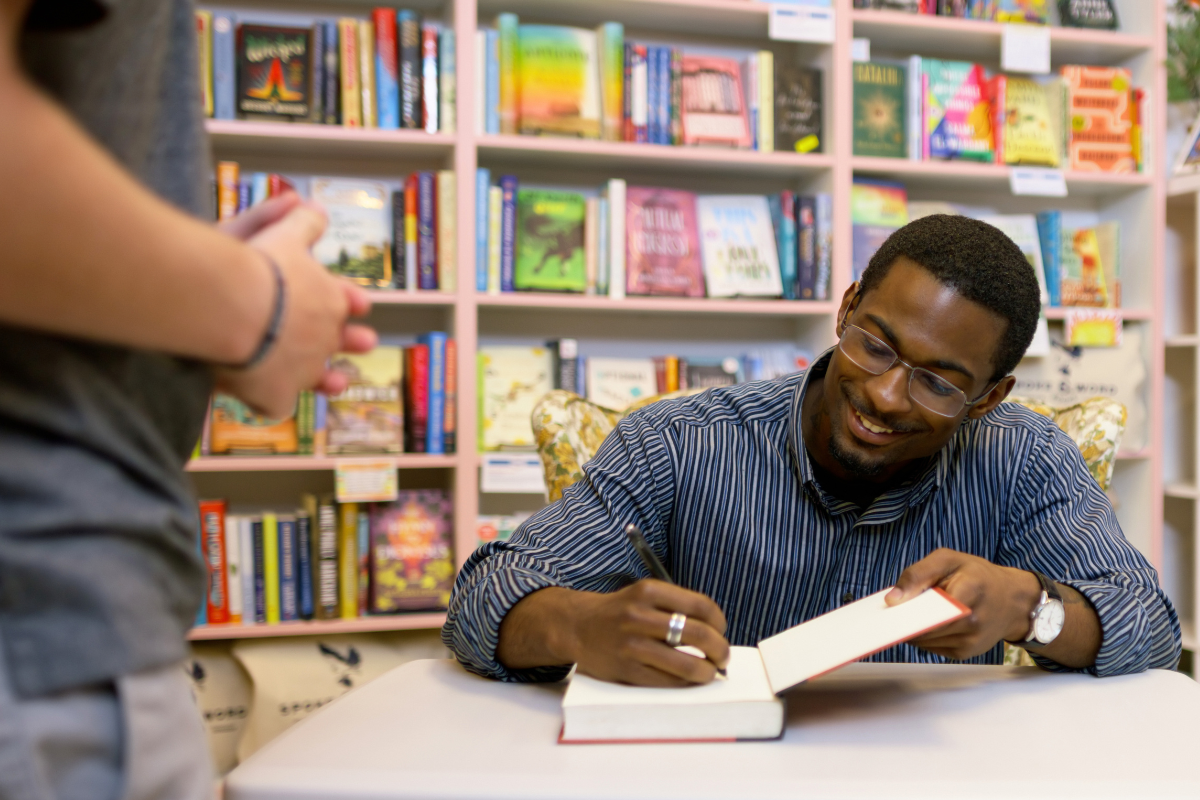 An author signs a copy of their book