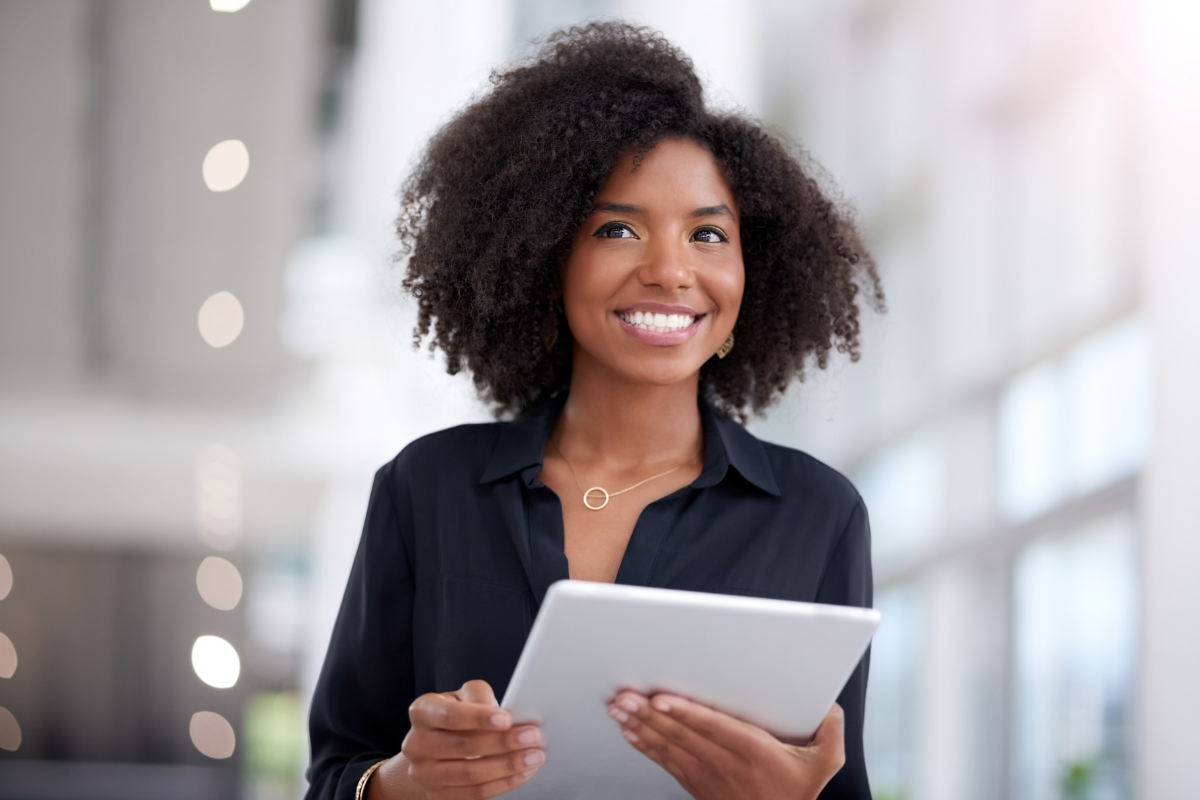 A person smiling and holding a tablet