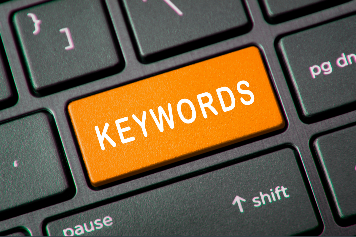 A keyboard where the enter key has been replaced with an orange key that says keywords