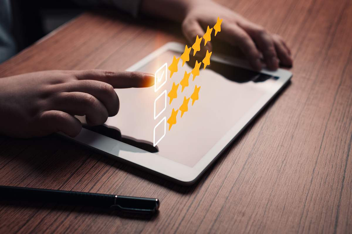 A person gives a five star review on a tablet