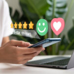 A person uses their phone to write a five-star review