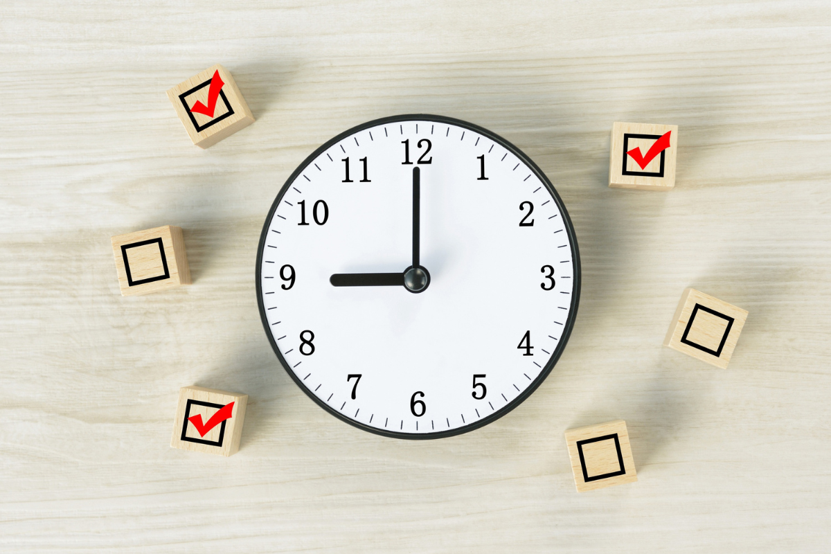 Wooden blocks with check marks on them surrounding a clock