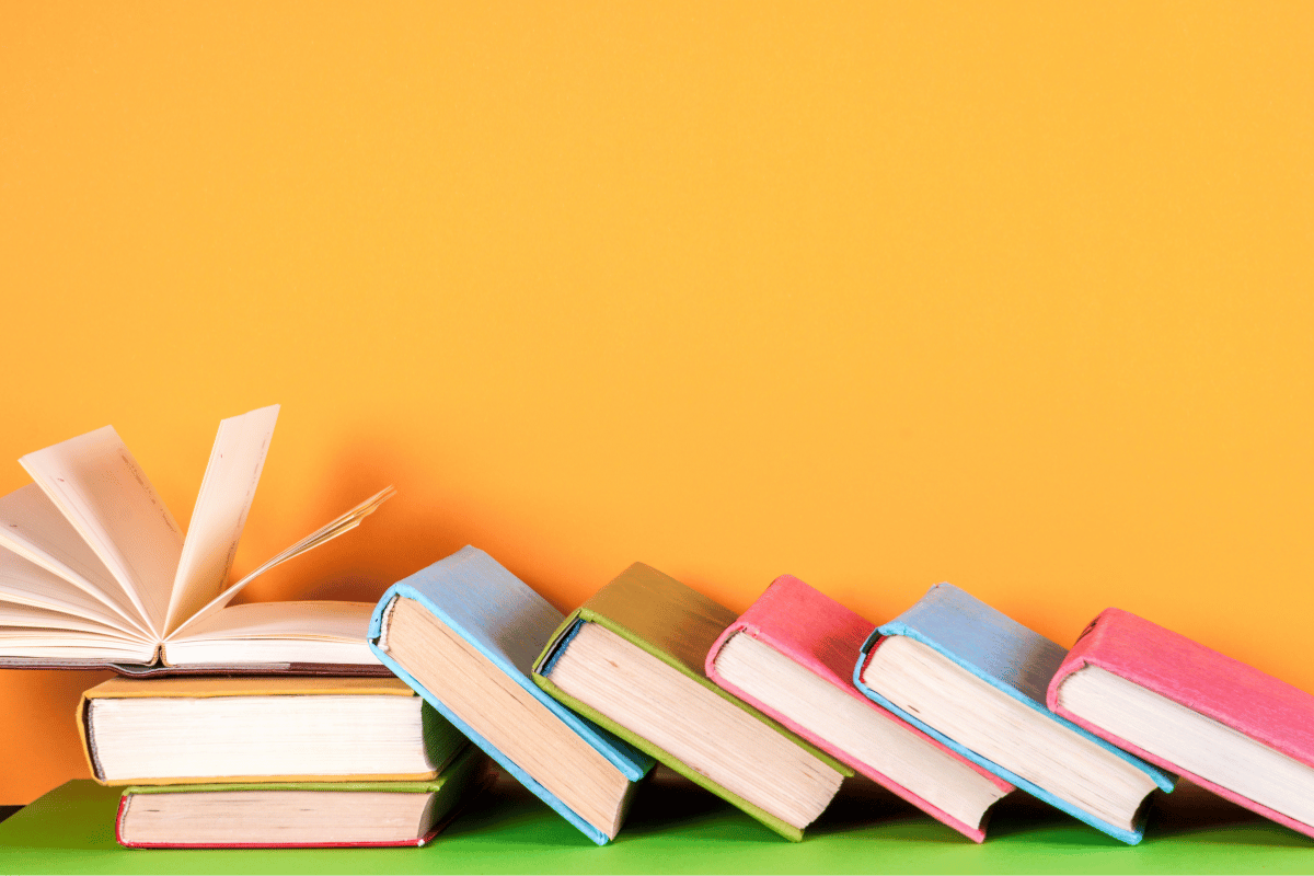 A stack of books in a line tipped over like dominoes