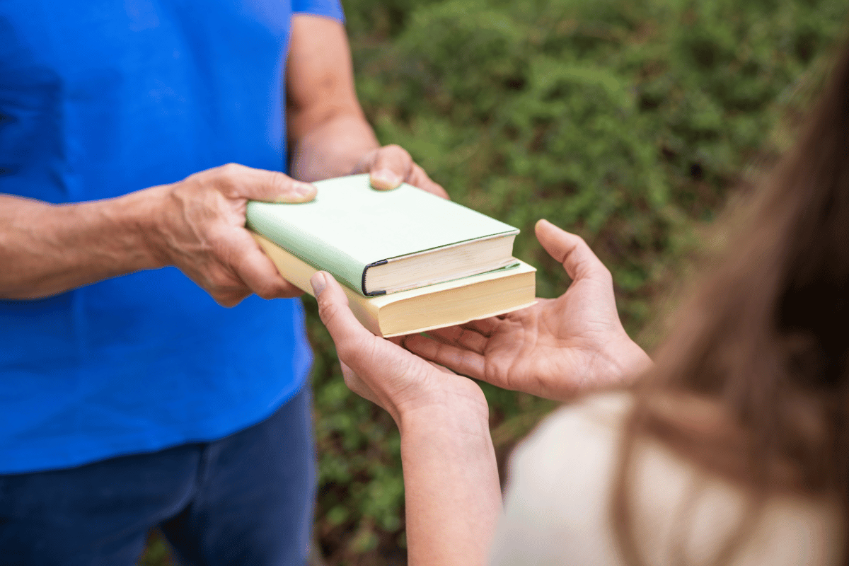 A person gives books to another