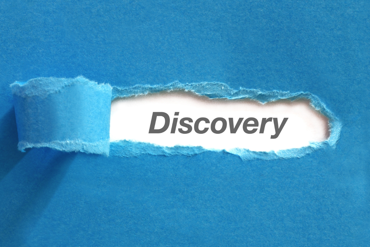 Blue paper torn to reveal the word discovery