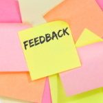 A stack of sticky notes with one reading "feedback."