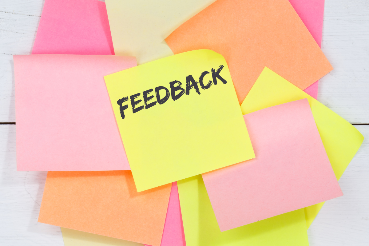 A stack of sticky notes with one reading "feedback."