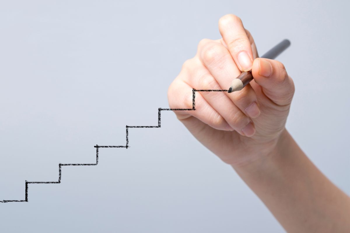A person uses a marker to draw stairs