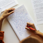 A person writes in a notebook