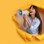 A person with a megaphone tears through a yellow paper foreground