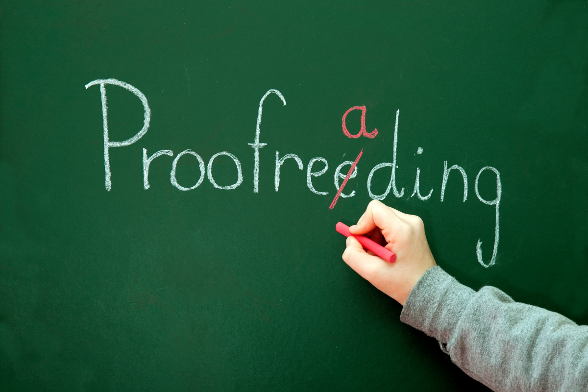 A person correcting a misspelling of proofreading on a chalkboard