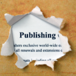 Patterned paper torn to reveal the definition of the word publishing