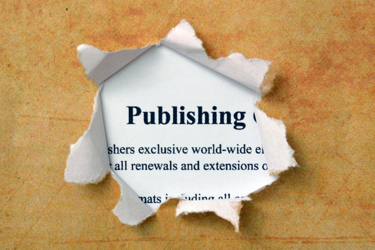 Patterned paper torn to reveal the definition of the word publishing