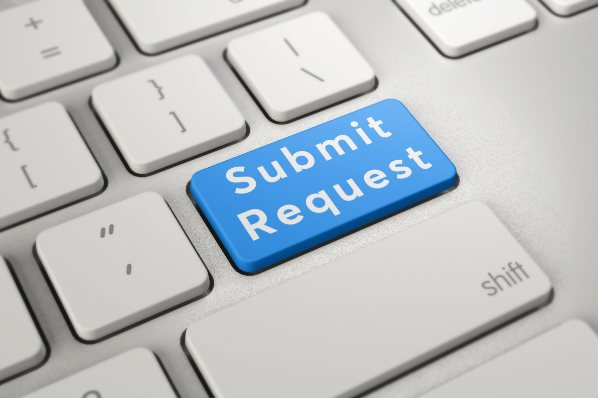 A laptop keyboard where the enter key says "submit request"