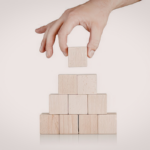 A person stacks wooden blocks into a tower