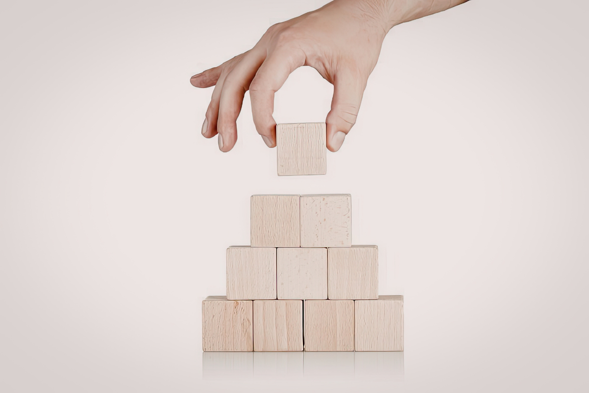 A person stacks wooden blocks into a tower