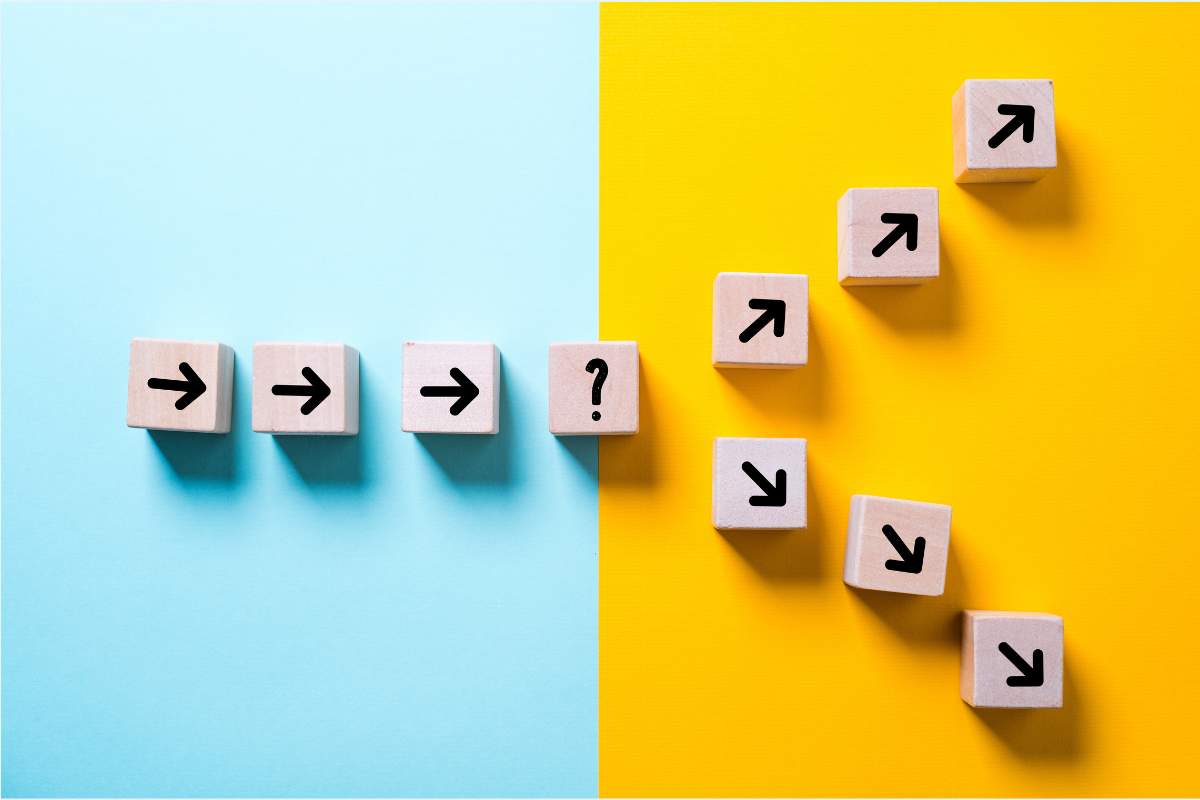 Wooden blocks with arrows on them illustrate two diverging paths